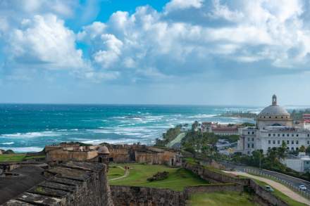 Captivating view of the historic San Juan coastline with El Morro fortress and ocean waves.