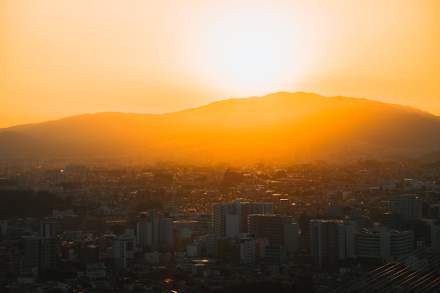 Captivating sunset view over Икеда cityscape with distant mountains in Osaka, Japan.